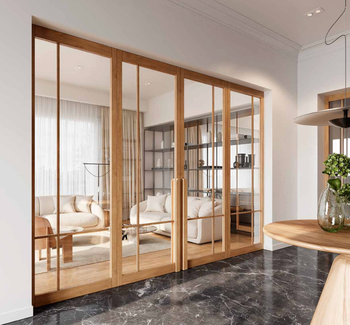 Wood-framed glass sliding partition doors installed in a modern interior, separating a living room with cream sofas and shelving from a kitchen or dining area with a dark marble floor.